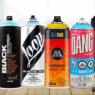 Colorful spray paint cans from top graffiti brands like Montana, Molotow, Loop, Kobra, and Ironlak arranged artistically on a graffiti-covered wall.